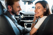 © LIGHTFIELD STUDIOS - happy bearded man looking at attractive woman in car