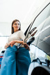 © LIGHTFIELD STUDIOS - selective focus of attractive woman standing near modern car