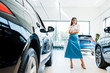 © LIGHTFIELD STUDIOS - selective focus of pensive woman standing near cars