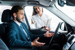 © LIGHTFIELD STUDIOS - attractive woman looking at handsome bearded man gesturing while sitting in car