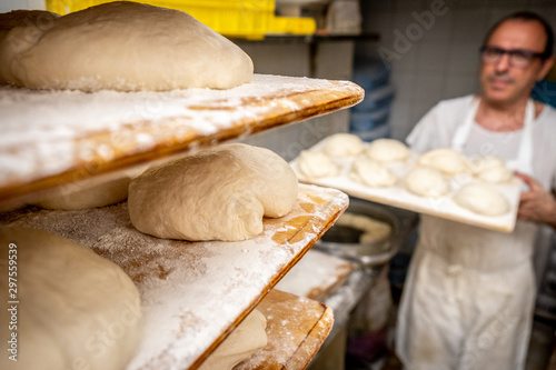 Fotografía Real artisan baker prepares bread dough in trays to be baked