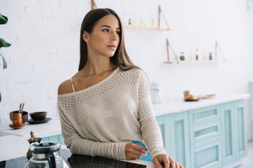 beautiful tender girl with long hair posing in kitchen at home