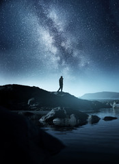 Wall Mural - calm midnight adventures. a long exposure shot of a man staring up into the night sky, silhouetted a