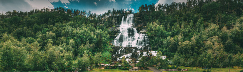 Wall Mural - Voss, Hordaland, Norway. Waterfall Tvindefossen In Spring. Largest And Highest Waterfall Of Norway. Famous Natural Norwegian Landmark And Popular Destination. Panorama, Panoramic View