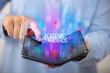 © ra2 studio - Young man holding a foldable smartphone with ACADEMIC STANDARDS inscription, educational concept