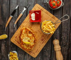 Wall Mural - chicken breast patties garnished with lemon, served with fries, mayonnaise and ketchup