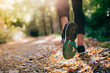 Leinwandbild Motiv Closeup of running shoe of the person running in the nature with beautiful sunlight.