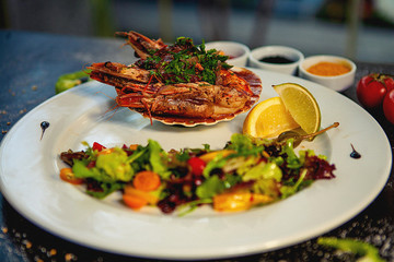 Poster - fried shrimps in garlic sauce served in shell, with fresh salad and lemon