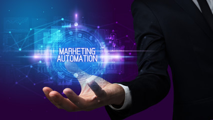 Man hand holding MARKETING AUTOMATION inscription, technology concept