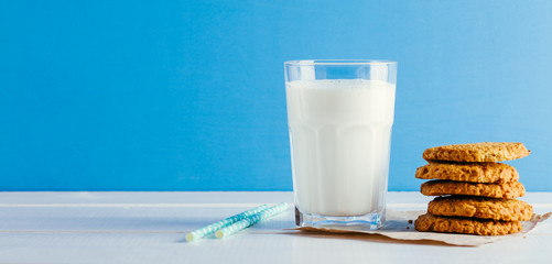 Wall Mural - Fresh milk and tasty cookies on a blue background