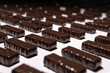 chocolate candies on the conveyor of a confectionery factory close-up