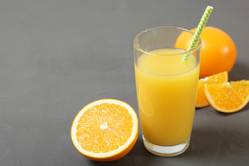 Orange juice in a glass, oranges and orange slices on the table.