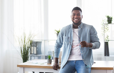 Poster - Successful businessman leaning on office desk and looking at camera