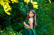 Beautiful brunette girl in glamorous green dress in nature. Ready for prom night