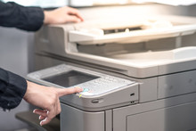 Male Hand Pushing Button On Photocopier Copying And Printing Report Paperwork In Office. Electronic Equipment And Supply For Business Organization.