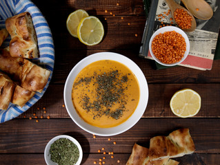 top view of lentil soup garnished with dried mint, served with lemon