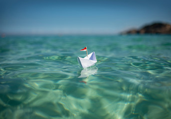 Sticker - Papierschiff fährt im türkisen Wasser