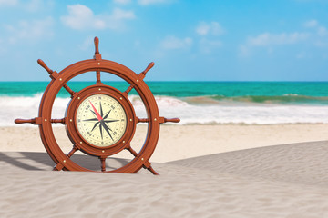Poster - vintage wooden ship steering wheel with rare compass on an ocean deserted coast. 3d rendering