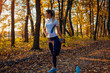 © maryviolet - Training and exercising after run in autumn park. Woman stretching legs outdoors. Active healthy lifestyle