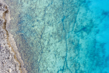 An aerial view of the beautiful Mediterranean sea, where you can se the rocky textured underwater corals and the clean turquoise water of blue lagoon Agia Napa