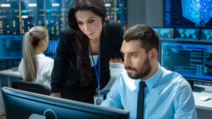 Fototapete - Female Chief Computer Engineer Consults Male Neural Network Architect. They Work in a Crowded Office on a Neural Network/ Artificial Intelligence Project. Office Space Has Data Server