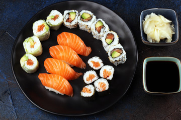 Wall Mural - close up of sashimi sushi set with chopsticks and soy - sushi roll with salmon and sushi roll with smoked eel