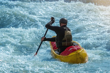 A Man In A Yellow Canoe Doing White Water Rafting 