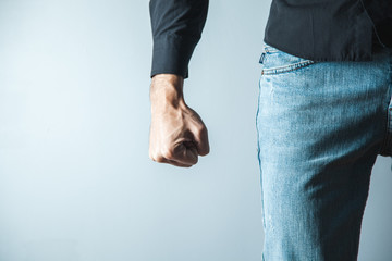 angry man fist on gray wall background