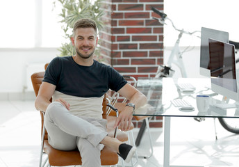 Canvas Print - confident young man sitting at his workplace