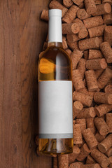 Template of white glass bottle of wine on corks and wood background. Poster concept design photo shooting