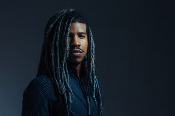 Portrait of a  serious young man with cool hair  and cool black and gray hair in studio