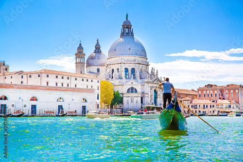 gondolier-and-gondola-on-grand-canal-basilica-santa-maria-della-salute-in-venice-italy-sunny-summer-day-with-blue-sky
