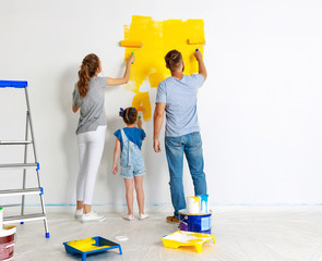 Wall Mural - Repair in apartment. Happy family mother, father and child daughter  paints wall .