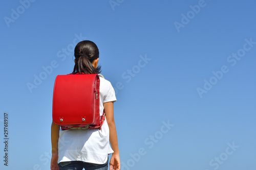 青空に立つ小学生の女の子 後姿 Adobe Stock でこのストック画像を購入して 類似の画像をさらに検索 Adobe Stock