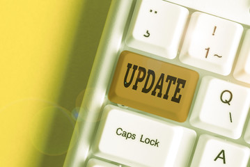 Text sign showing Update. Business photo showcasing make something more modern or up to date like software programs White pc keyboard with empty note paper above white background key copy space