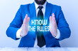 © Artur - Word writing text Know The Rules. Business photo showcasing set explicit or regulation principles governing conduct Man holds empty paper with copy space in front of him Space