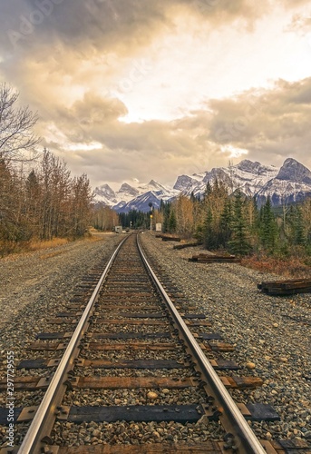 Fotografía Canadian Pacific Railway Line and Distant Mountain Peaks Landscape against Drama
