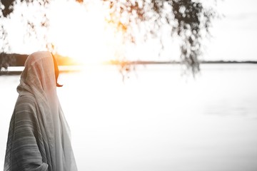 Person wearing a biblical robe looking in the distance shot from behind