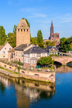 Close-up On The Heinrichsturm Tower And The Ponts Couverts (covered Bridges) On The River Ill In The Petite France Historic Quarter In Strasbourg, France, With Notre-Dame Cathedral In The Distance.