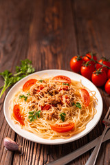 Wall Mural - Pasta bolognese with tomato sauce and minced meat, grated parmesan cheese and fresh parsley - homemade healthy italian pasta on rustic wooden background.