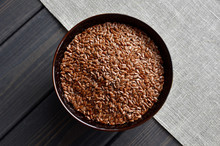 Flax Seeds In Bowl On Linen Fabric Background