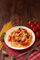 Wall Mural - Pasta carbonara with tomato sauce and minced meat, grated parmesan cheese and fresh parsley - homemade healthy italian pasta on rustic wooden background. 