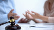 © motortion - Spouses arguing about property division during divorce, gavel and rings closeup