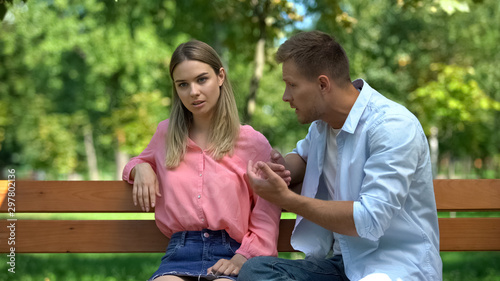 Fotografía Offended woman listening to boyfriend explanations sitting park after quarrel