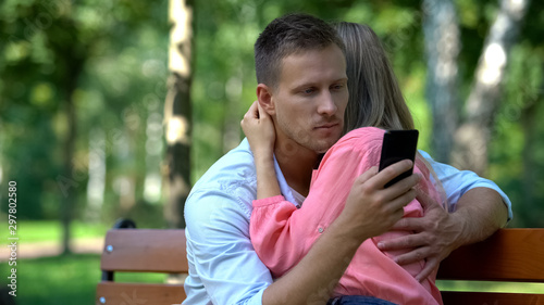 Fotomural Boyfriend texting message another woman while hugging girlfriend, betrayal