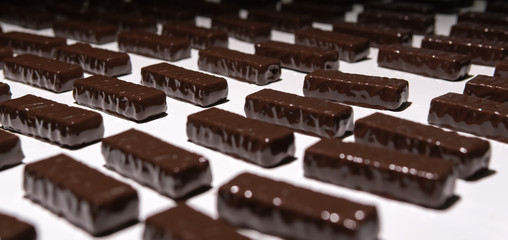 Wall Mural - chocolate candies on the conveyor of a confectionery factory close-up