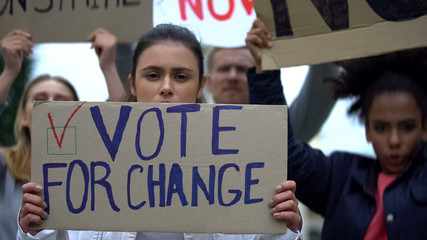 Sad girl showing slogan Vote for change, presidential campaign rally, democracy