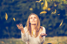 Woman Throwing Leaves In The Air