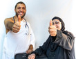 © Diya - Muslim woman and her son wearing pilgrimage clothes and their thumbs up