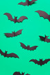 Halloween paper vampire bat decorations on a green background.